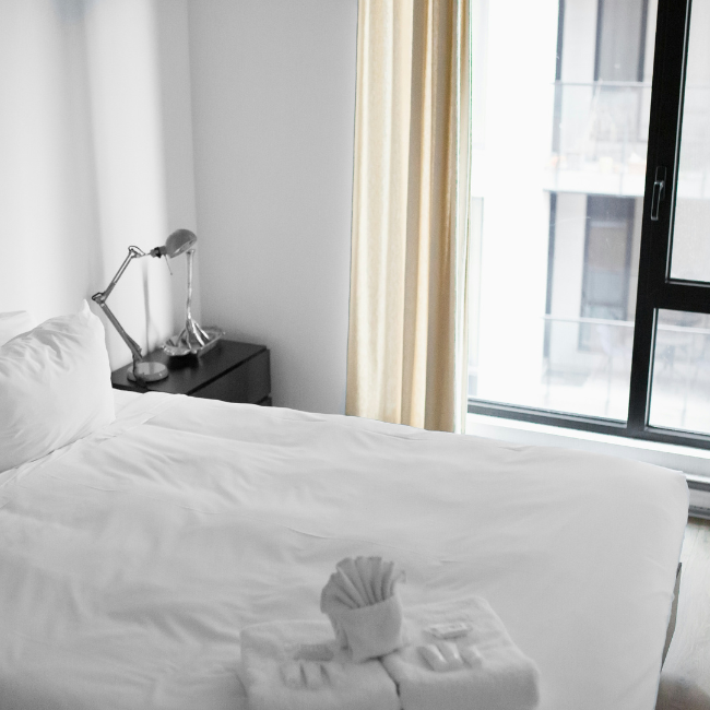 White bed sheet in a well-lit bedroom 